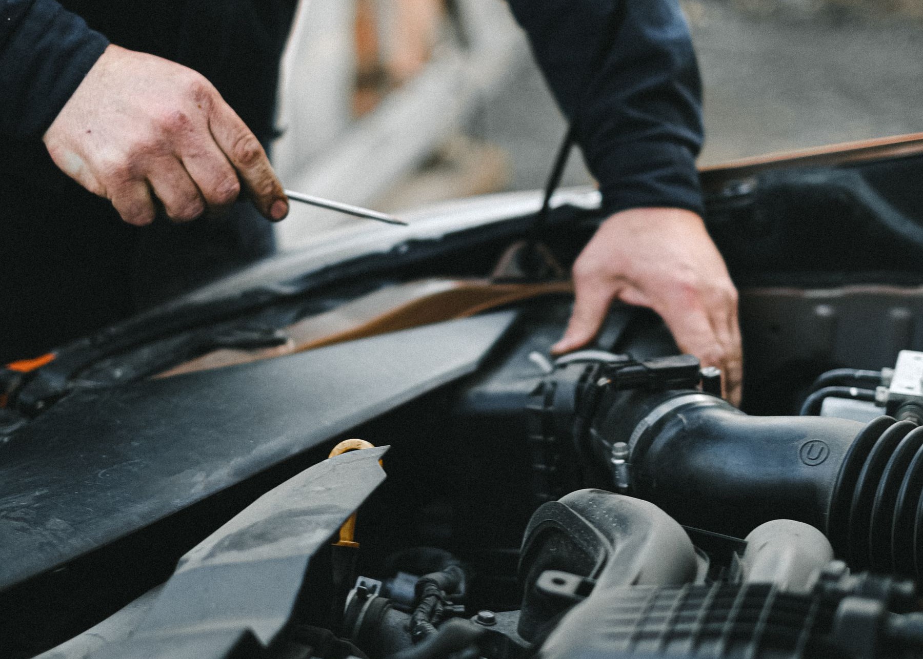 Illustrative stock photograph of a mechanic inspecting a passenger vehicle engine